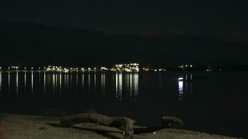 sjö på natt med se av stad lampor foto