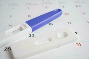 graviditet testa för kvinna på kalender, ägglossning dag. foto