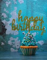 Lycklig födelsedag muffin med blå glasyr och strössel foto