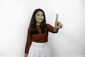 upphetsad asiatisk kvinna bär en röd t-shirt ger siffra 1 förbi henne index finger, pekande gest foto
