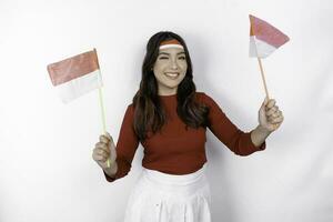 upphetsad ung asiatisk kvinna fira indonesiska oberoende dag innehav de indonesiska flagga isolerat på vit bakgrund foto