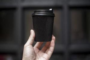 mänsklig hand som håller kaffepapper, morgondryck foto