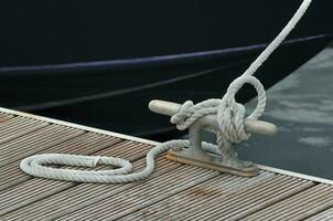 förtöjning båt - rep fästa till knap på brygga foto