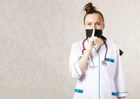 en ung kvinna klädd i en medicinsk enhetlig med en stängd mun foto