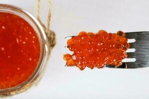 röd kaviar på en metall gaffel. foto