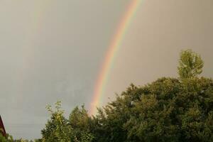 full regnbåge efter regn mot de himmel foto