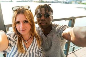 multietnisk par har roligt tar en selfie med smartphone foto