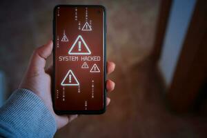 kvinna visar smartphone med systemet hackat varna på skärm. äventyras information begrepp. internet virus cyber säkerhet och Cyber brott. foto