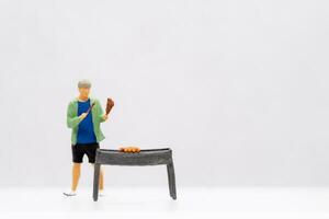 miniatyr- människor ung man grillning bbq foto