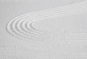 zen trädgård med linje mönster på vit sand i japansk stil, sand textur yta med Vinka parallell linjer, bakgrund baner för meditation, zen tycka om koncept, enkelhet dag foto