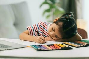 liten asiatisk barn teckning med Färg pennor på tabell på Hem foto