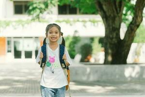 porträtt av söt asiatisk barn flicka med ryggsäck gående till skola foto