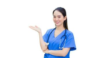en vacker ung asiatisk läkare i blå uniform står och ler samtidigt som den pekar mot toppen på en vit bakgrund. foto