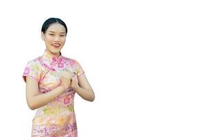 skön asiatisk kvinna med lång hår vem bär rosa Cheongsam klänning i kinesisk ny år tema medan hon visar henne hand som kinesisk hälsning med på vit bakgrund. foto