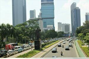 jakarta, Indonesien-18 juni 2023 se av sudirman gata med sudirman staty i de mitten foto