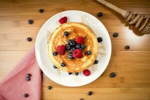 amerikan pannkakor med blåbär och hallon, över trä- yta foto