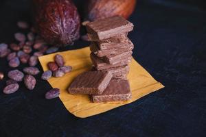 choklad och kakaobönor med kakao på en svart bakgrund foto