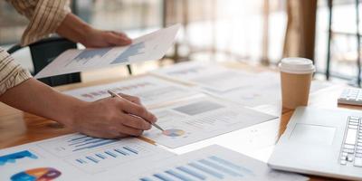 affärsman investeringskonsult analysera företagets årsredovisning balansräkningen arbetar med dokument grafer. konceptbild av företag, marknad, kontor, skatt. foto