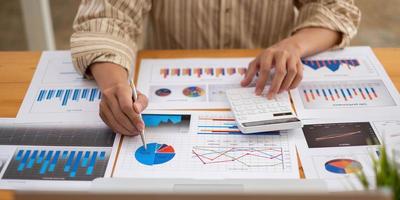 affärsman investeringskonsult analysera företagets årsredovisning balansräkningen arbetar med dokument grafer. konceptbild av företag, marknad, kontor, skatt. foto