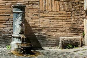 typisk antik offentlig dricka fontän på de gator av rom foto