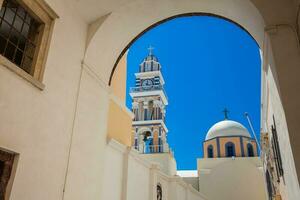 klocka torn och kupol av de helgon john de baptist kyrka i de stad av fira i de ö av santorini foto