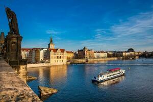 båt navigerande på vlava flod på solnedgång i prag foto