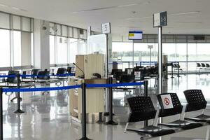 tömma vattning rum på ett flygplats under covid 19 pandemi med social avstånds tecken på stolar foto