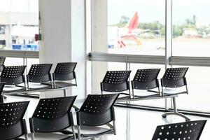 tömma vattning rum på ett flygplats under covid 19 pandemi med social avstånds tecken på stolar foto