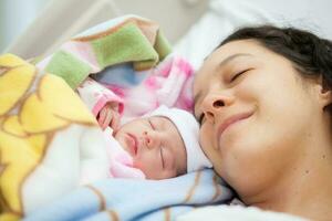 nyfödd flicka med henne mamma i de sjukhus på de dag av henne födelse. moderskap begrepp foto