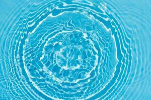 blå vatten med krusningar på de yta. defokusering suddig transparent blå färgad klar lugna vatten yta textur med stänk och bubblor. vatten vågor med lysande mönster textur bakgrund. foto