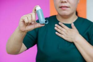 stänga upp kvinna hand innehar astma inhalator. begrepp, hälsa vård. farmaceutisk Produkter för behandling symptom av astma eller copd. använda sig av under recept. hälsa vård enhet på Hem. foto