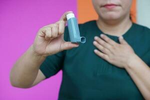 stänga upp kvinna hand innehar astma inhalator. begrepp, hälsa vård. farmaceutisk Produkter för behandling symptom av astma eller copd. använda sig av under recept. hälsa vård enhet på Hem. foto