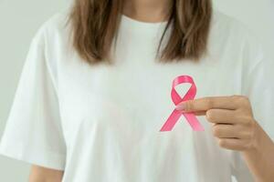 kvinna håll rosa band bröst cancer medvetenhet. kvinna hälsa kolla upp medvetande. internationell kvinnor dag och värld cancer dag. tecken cancer, symbolisk, hälsa vård, Stöd patienter, i god tid diagnos foto