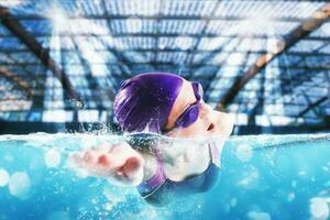 sportig kvinna idrottare simmar med energi under en konkurrens i de slå samman foto