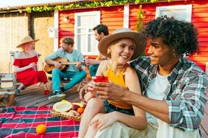 vänner ha en picknick och spela med gitarr foto