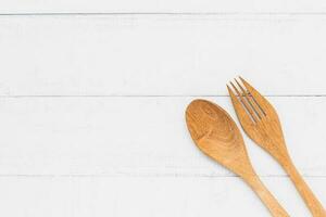 trä- sked och gaffel på vit tabell bakgrund för redskap och köksutrustning begrepp foto