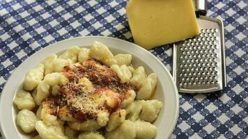 tallrik av hemlagad Gnocchi med riven ost på de tabell foto