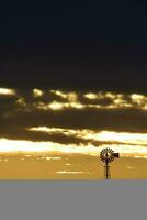 landskap med väderkvarn på solnedgång, pampas, patagonien, argentina foto