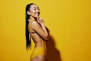 ung kvinna porträtt lycka leende överraskad skönhet ansikte trendig sommar gul baddräkt mode foto