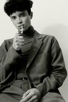 cigarett man Framställ hipster ser Sammanträde lockigt studerande omtänksam och vit manlig svart mode porträtt rökning foto