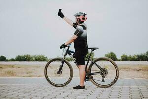 cyklist tar en selfie på hans cykel. knubbig cyklist i en sporter kostym tar en selfie på de väg foto