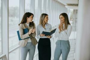 tre ung företag kvinnor gående på trappa i de kontor hall foto