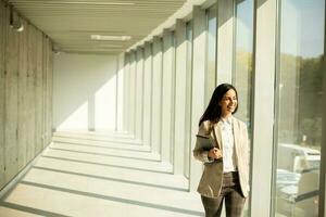 ung affärskvinna gående på modern kontor hall foto