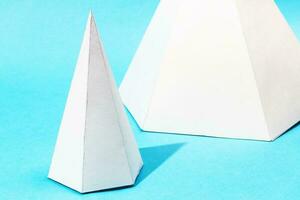 handgjort papper pyramider stänga upp på turkos blå foto