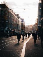 amsterdam, nederländerna 2018 - cyklister som rider på gatorna med fotgängare på trottoaren i amsterdam foto