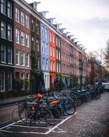 amsterdam, nederländerna 2018 - cyklar framför färgglada hus i amsterdam foto