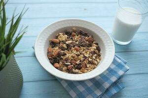 granola musli i en skål och glas av mjölk på talbe foto