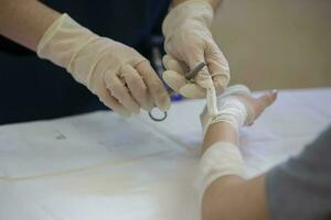 de läkare ties de patientens hand med en medicinsk bandage. foto