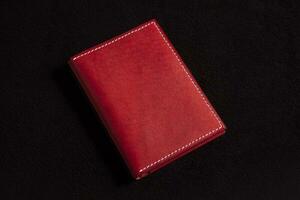 läder plånbok röd på en mörk bakgrund. foto