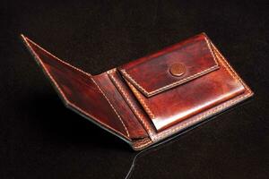 läder öppen plånbok i brun på en svart bakgrund. foto